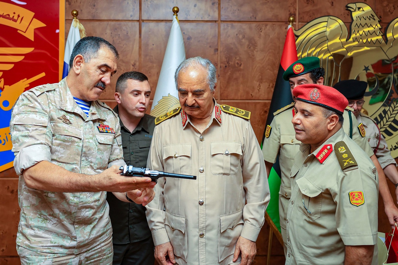 Remise d'une pistolet en cadeau entre hommes en uniforme.