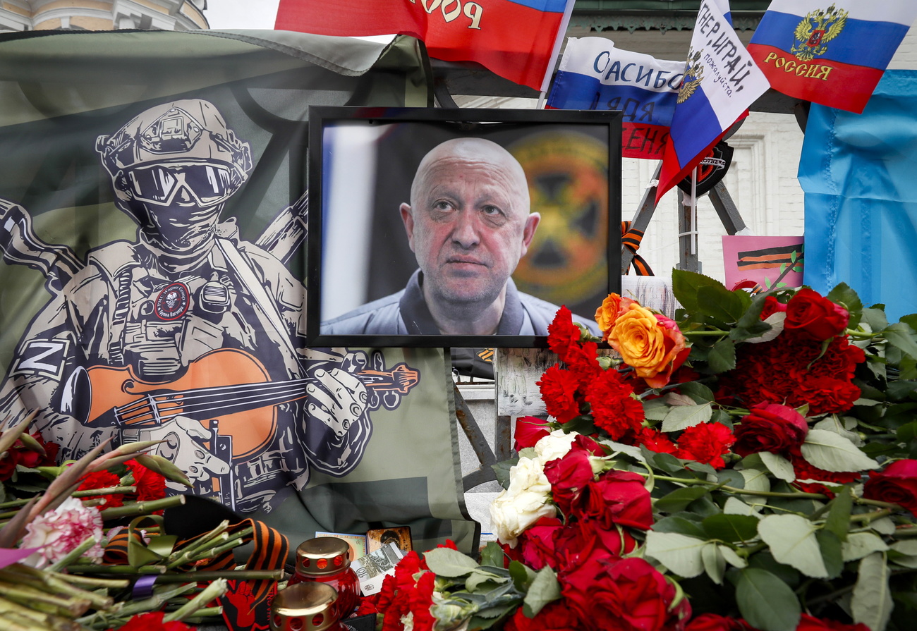 Roses, dessins et drapeaux autour de la photo d'un homme en uniforme.