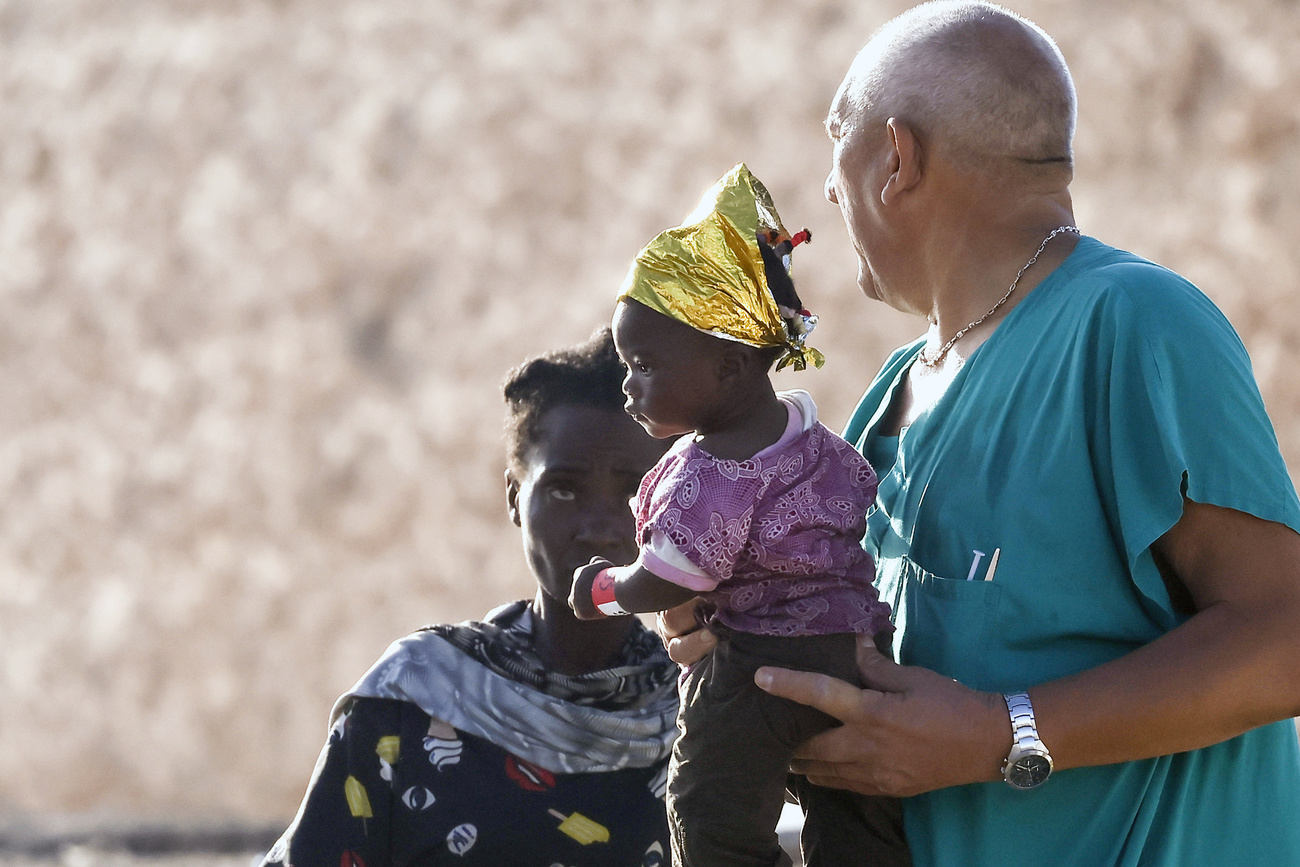 Un operatore umanitario tiene una bimba immigrata.