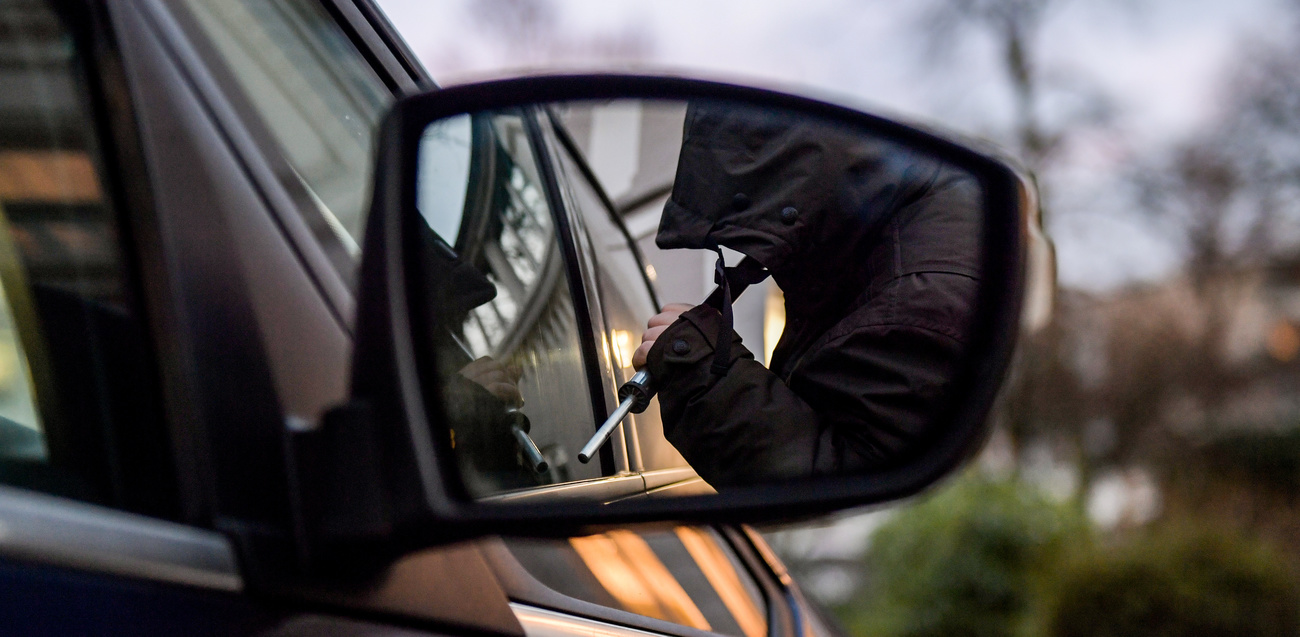 Un ladro alle prese con un auto.