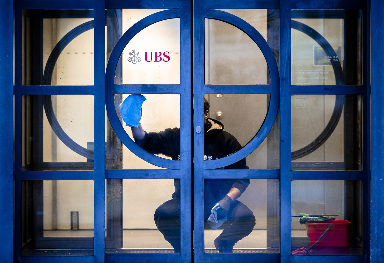Ein Mann wäscht eine Tür bei der UBS