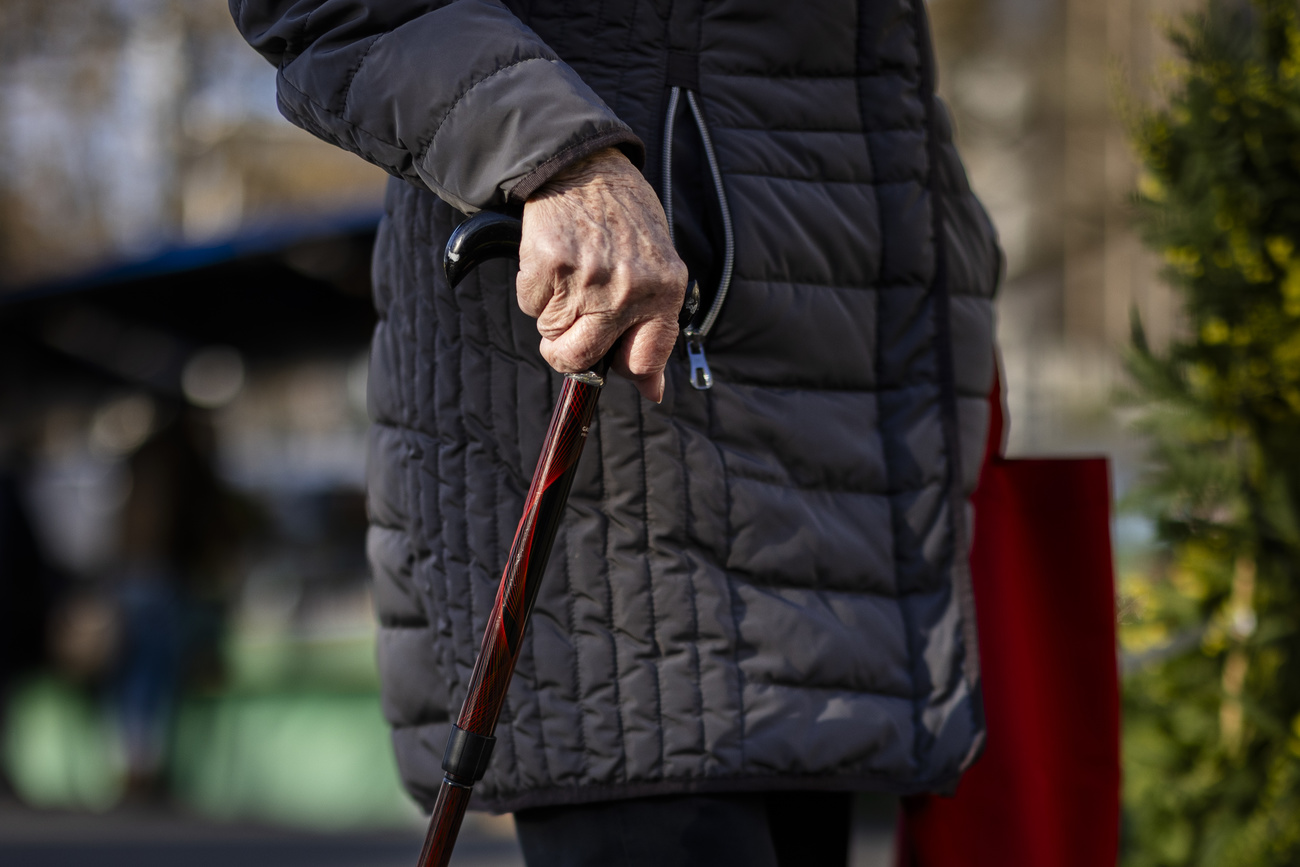 die Händ einer älteren Person an einem Gehstock