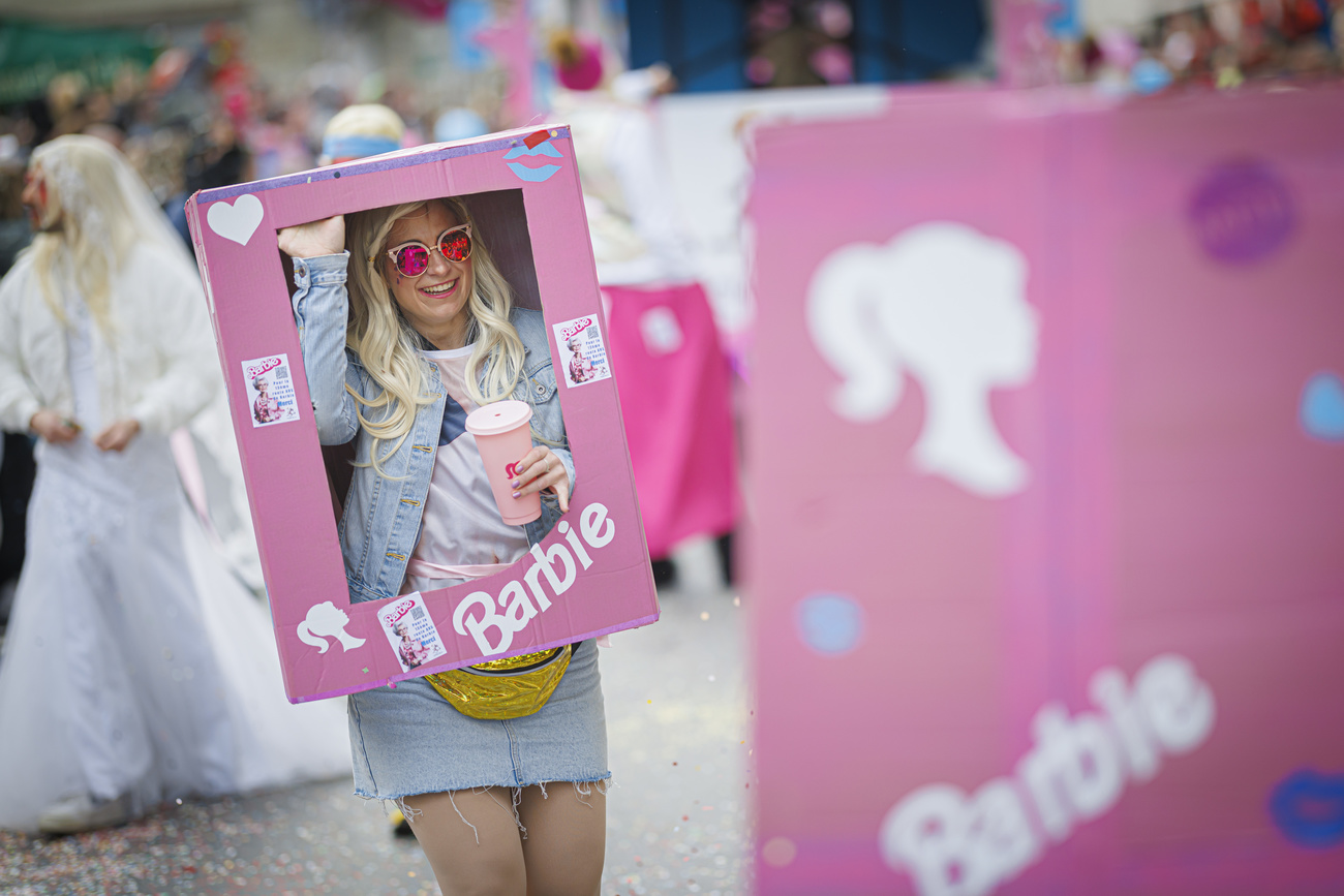 A reveler dressed as a Barbie in a box parades during the 129th edition of the "Brandons de Payerne" carnival in Payerne, Switzerland, Sunday, February 18, 2024. (KEYSTONE/Valentin Flauraud)