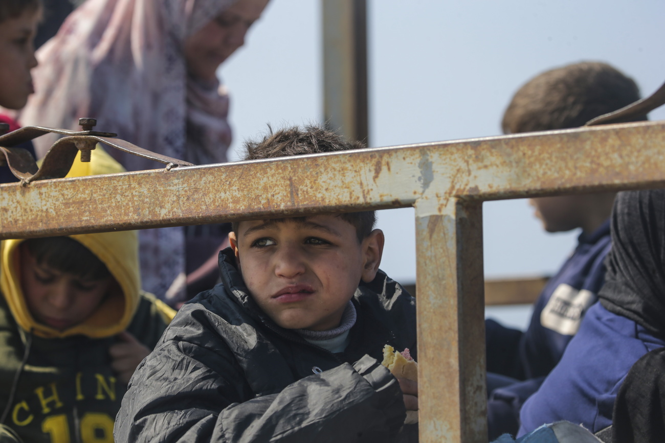 A boy sits in the back of a truck