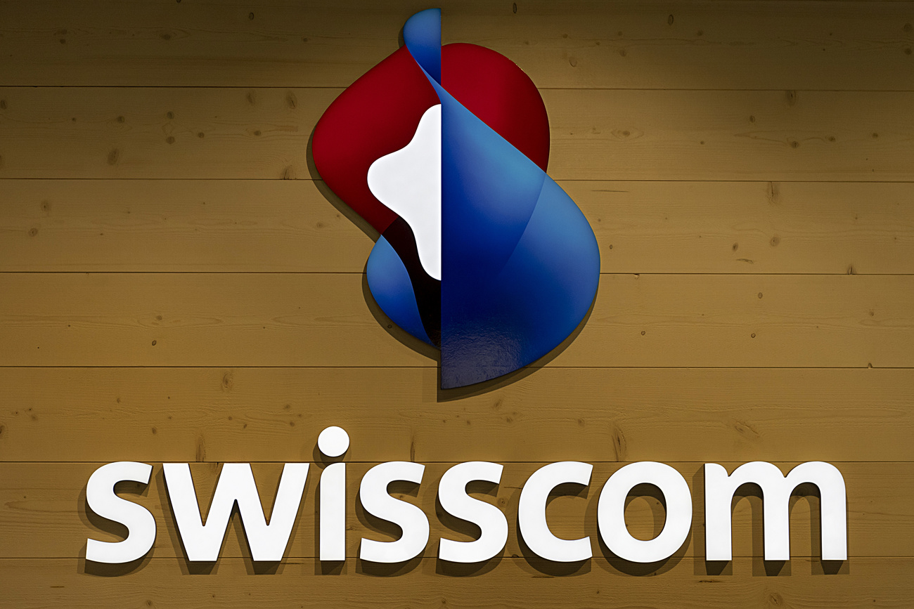 The Swisscom company logo is shown on a wall.