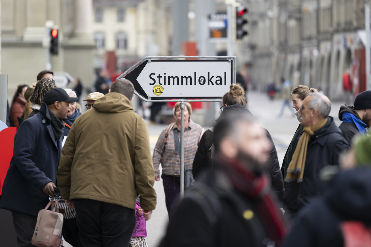 Ein Wegweiser weist den Weg zum Stimmlokal in der Stadt Bern, am Sonntag, 3. Maerz 2024, in Bern. Die Schweizer Buergerinnen und Buerger stimmen ueber die Renteninitiative und die Initiative fuer eine 13. AHV-Rente ab. (KEYSTONE/Anthony Anex)
