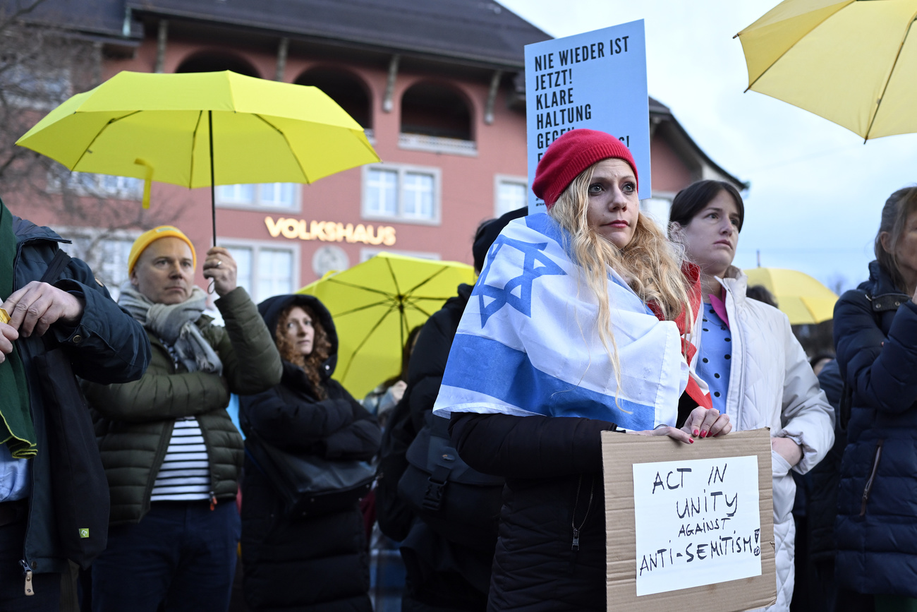 persone manifestano con ombrelli gialli