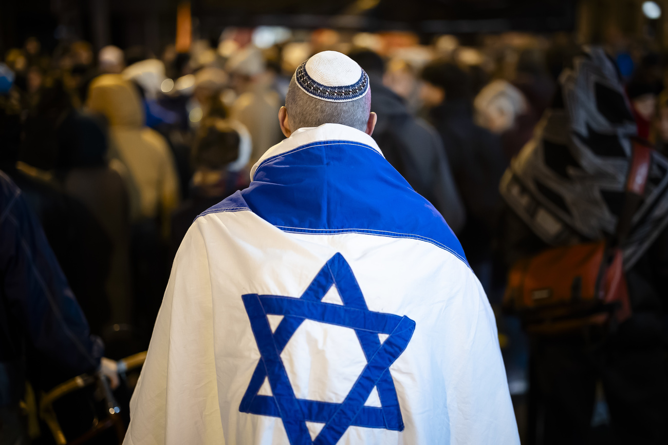 uomo ebreo con kippah e bandiera israeliana sulle spalle fotografato di spalle