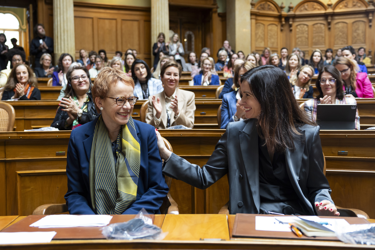 Women filling the seats of the Swiss federal palace clapping for Eva Herzog