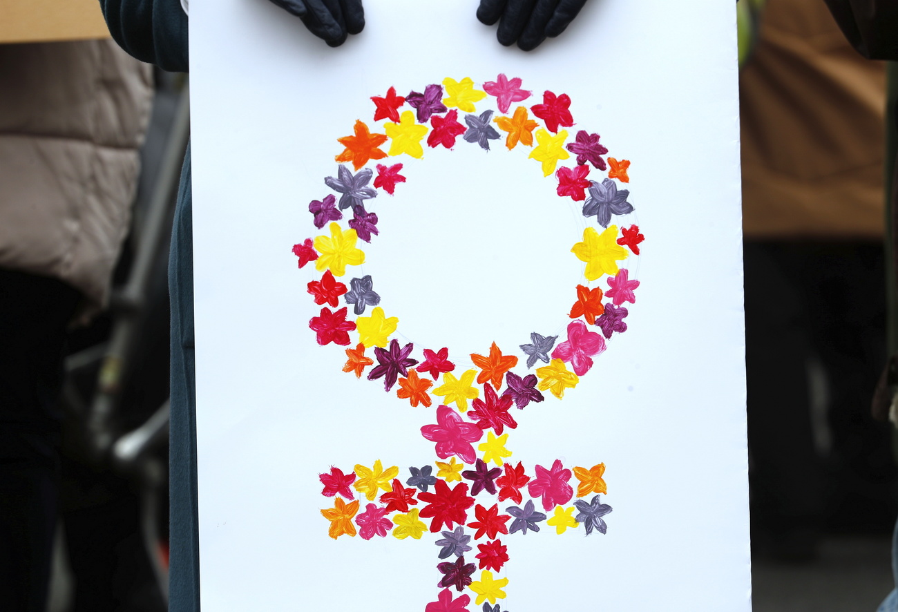 cartello con simbolo femminile formato da fiori multicolore su sfondo bianco
