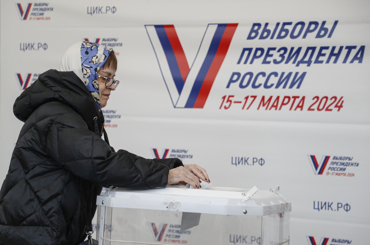donna russa inserisce la sua schedina di voto in un'urna
