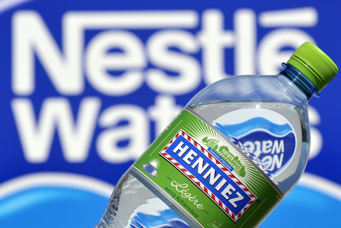 bottiglia di acqua henniez davanti al logo di nestlé waters