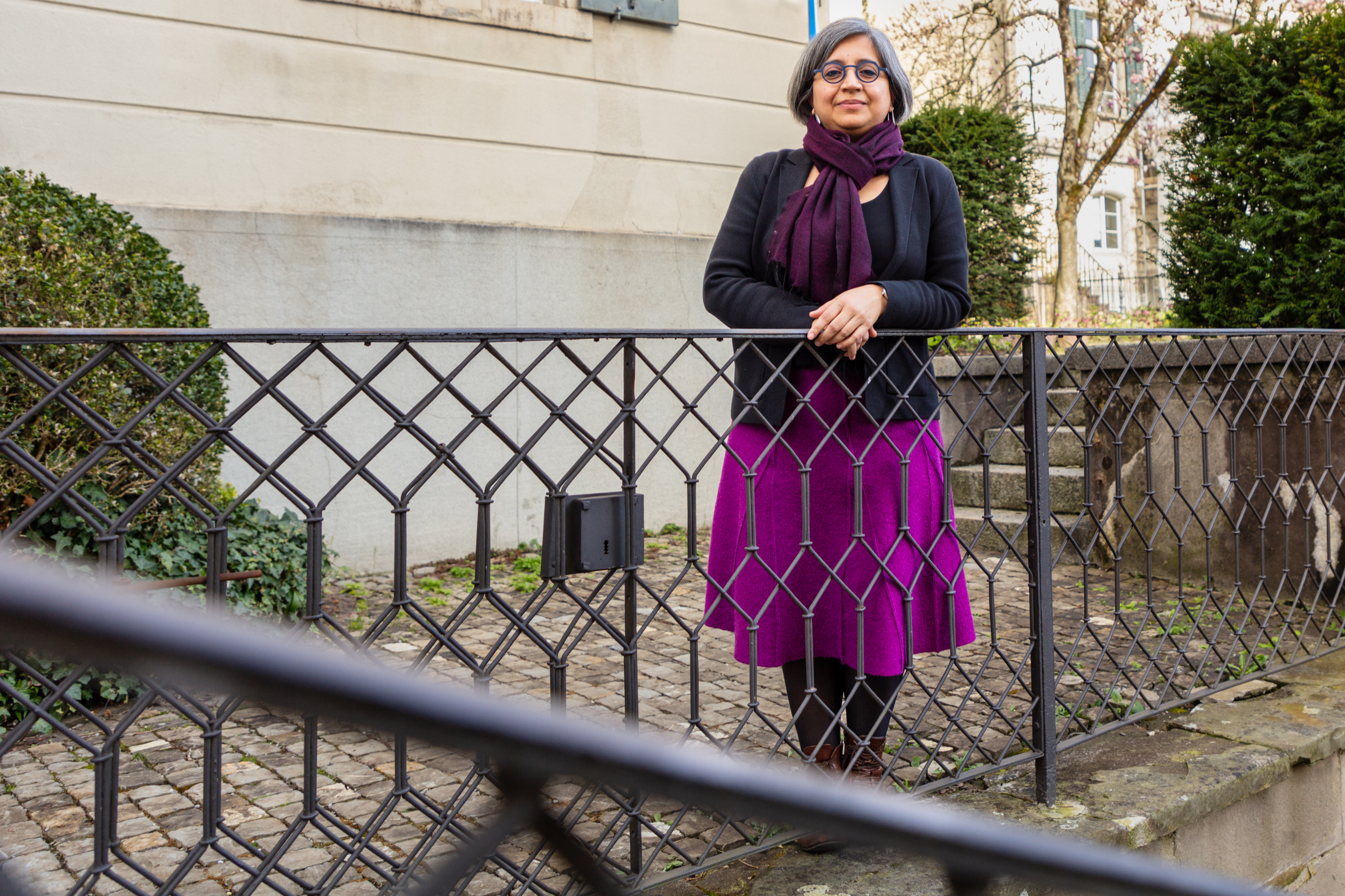 Femme indienne posant devant un bâtiment.