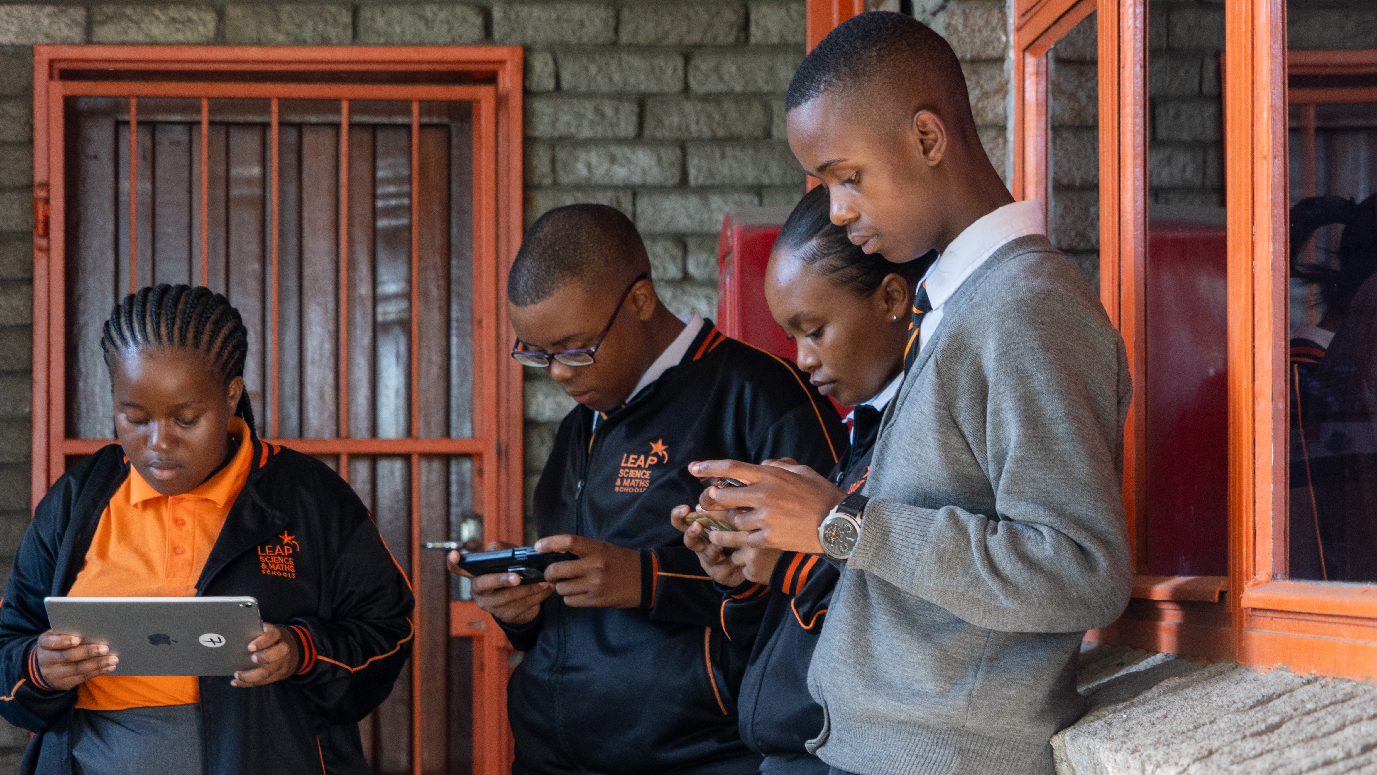 Eine Gruppe Jugendlicher im Township Langa ist ins Spiel mit der App vertieft.