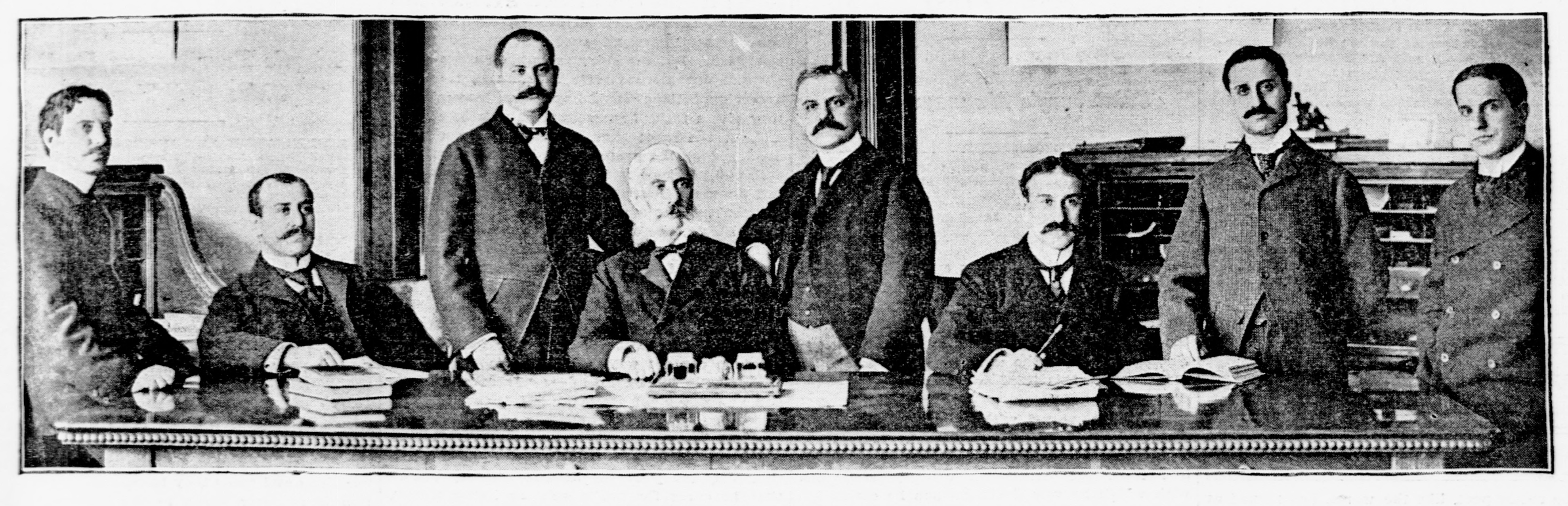 Un homme et ses sept fils derrière une table