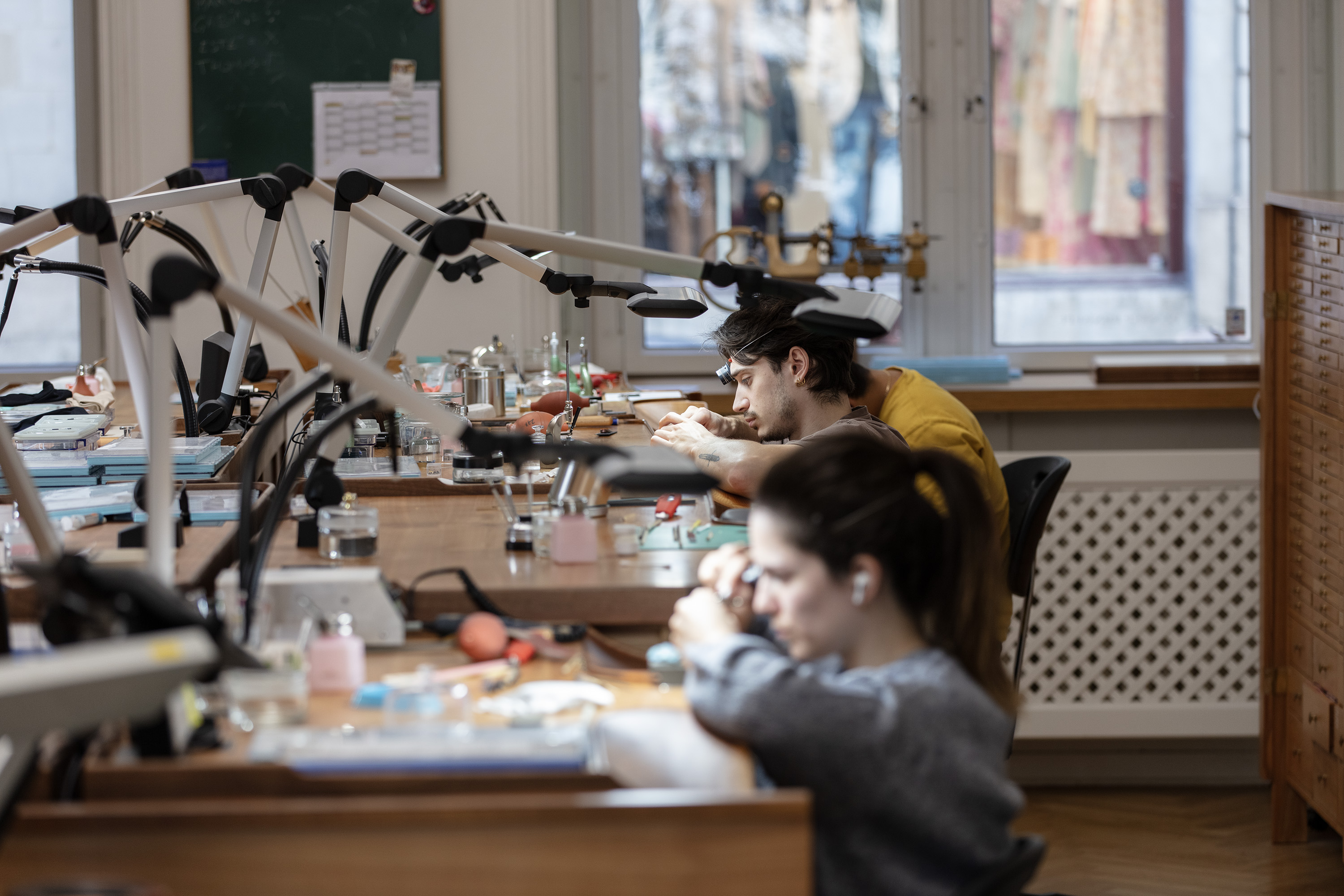 Personen bei der Arbeit im Uhrmacheratelier