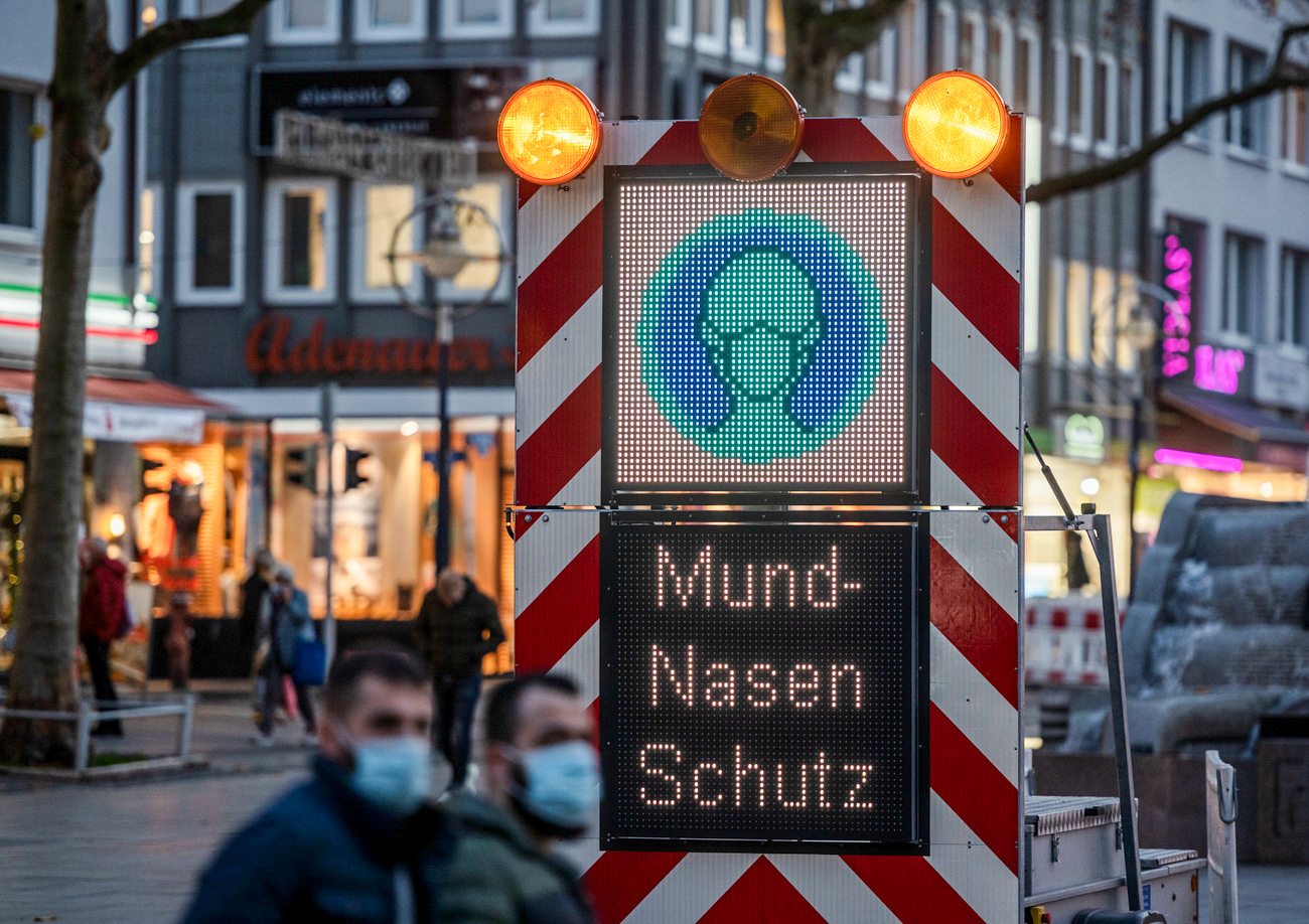 Leuchttafel mit Hinweis auf Mund Nasen Schutz in eienr Stadt
