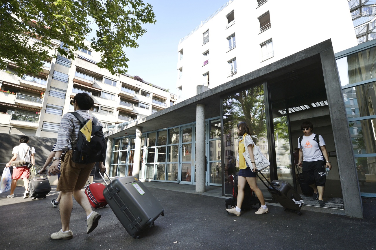 Picture of guests coming out of hostel with suitcases.