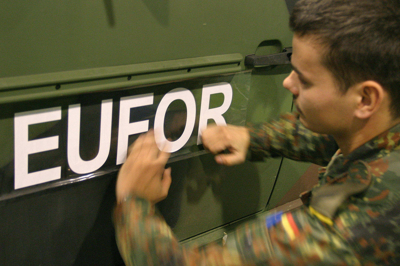 A German Army soldier, member of the peacekeeping forces in Bosnia, affixes a EUFOR sign to a vehicle