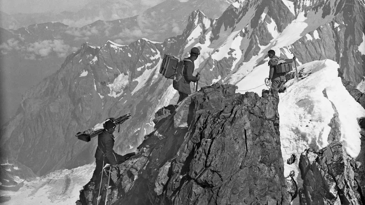 Eine schwarzweiss-Fotografie von Männern auf einem Berggipfel