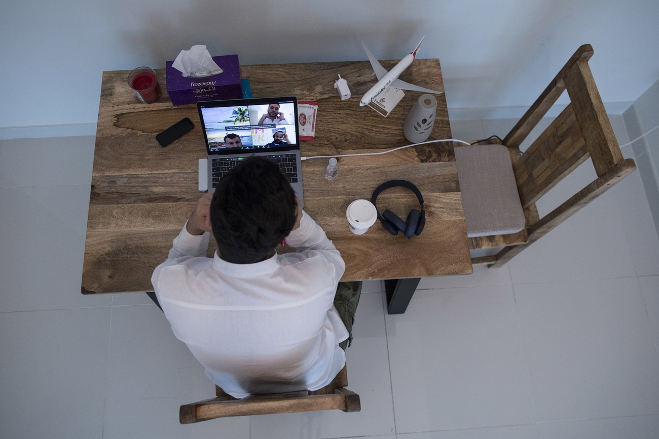 Un impiegato lavora sul al computer sul tavolo di casa.