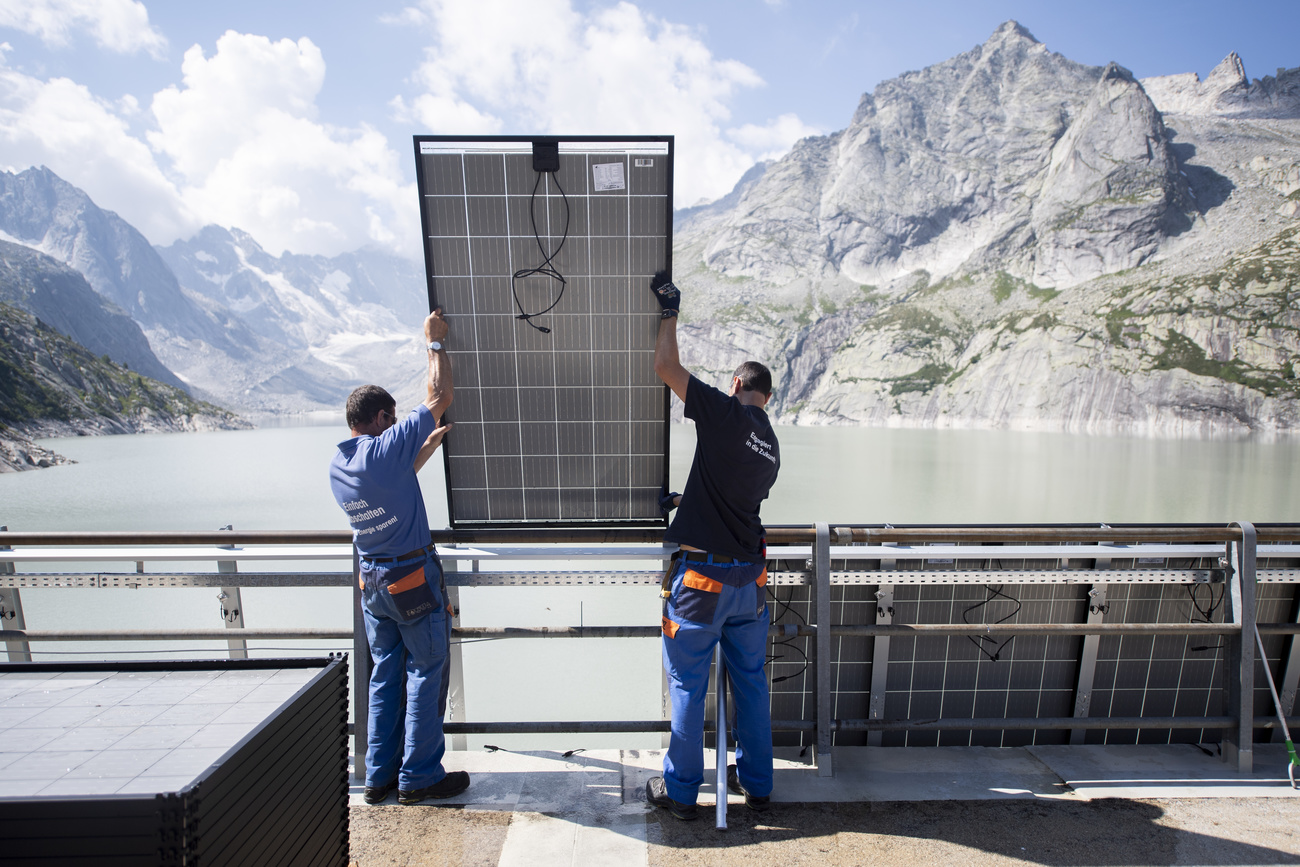 Arbeiter montieren Panels der Solar-Grossanlage des Elektrizitaetswerk der Stadt Zuerich (ewz) am Albigna-Stausee, aufgenommen am Montag, 10. August 2020, in Bregaglia. Mit über 1200 Modulen realisiert ewz auf der Staumauer im Bergell die erste Photovoltaik-Anlage im hochalpinen Gebiet auf rund 2100 Metern ueber Meer. Die Produktion soll den Jahresbedarf von 210 Haushalten abdecken (KEYSTONE/Gian Ehrenzeller)