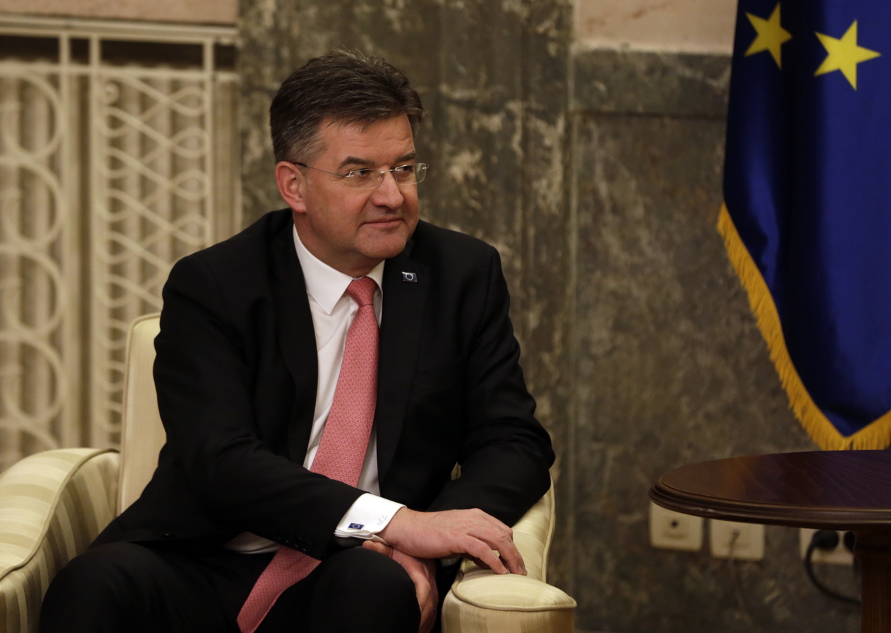 Picture of a man sitting on a chair by an EU flag