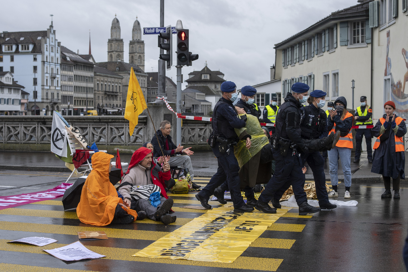 Agenti portano via un dimostrante a Zurigo nell'ottobre 2021.