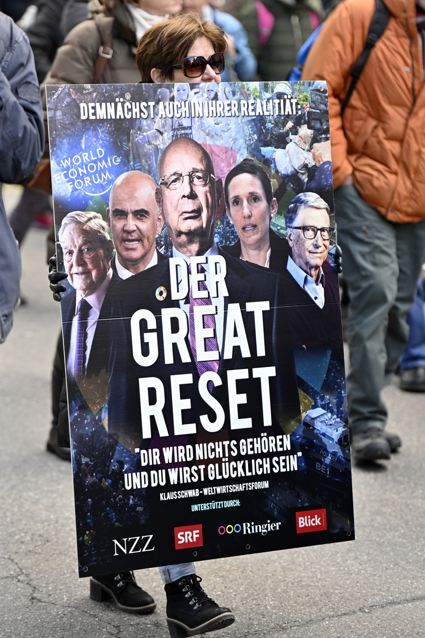 George Soros, Alain Berset, Klaus Schwab, Tanja Stadler, Bill Gates and the media are shown on a poster held by a protester against the Covid-19 measures. The photo was taken during a demonstration in Winterthur city, in canton Zurich on Saturday, February 26, 2022.