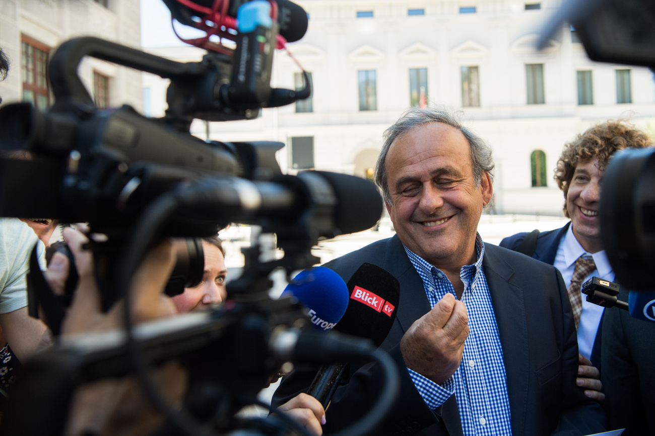 Platini sorride di fronte ai media.