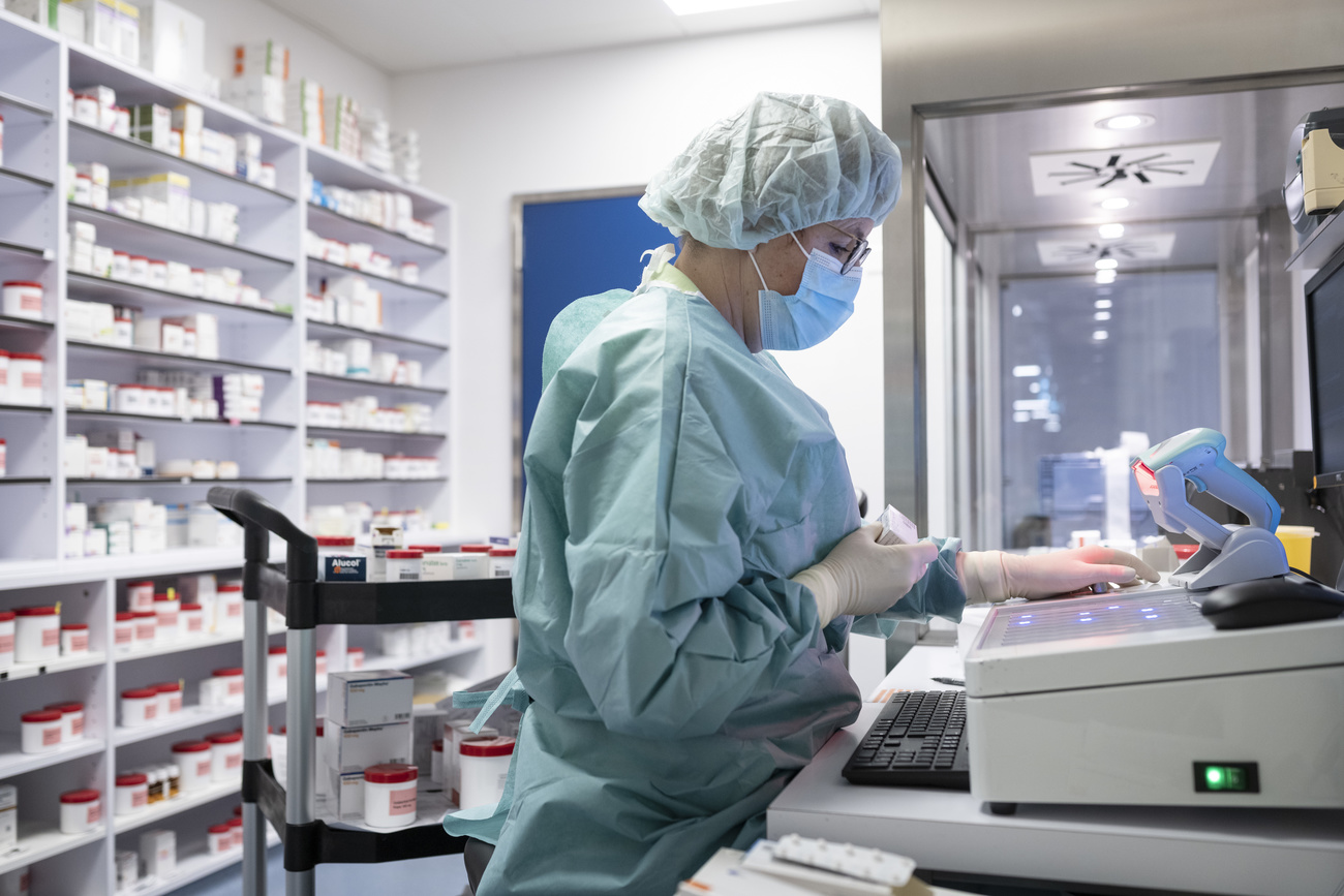 Eine Frau mit Schutzkleidung in einer Apotheke