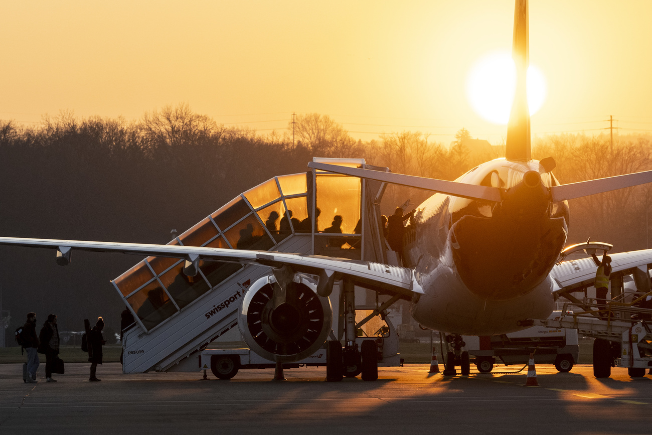 passeggeri salgono a bordo di un aereo al tramonto