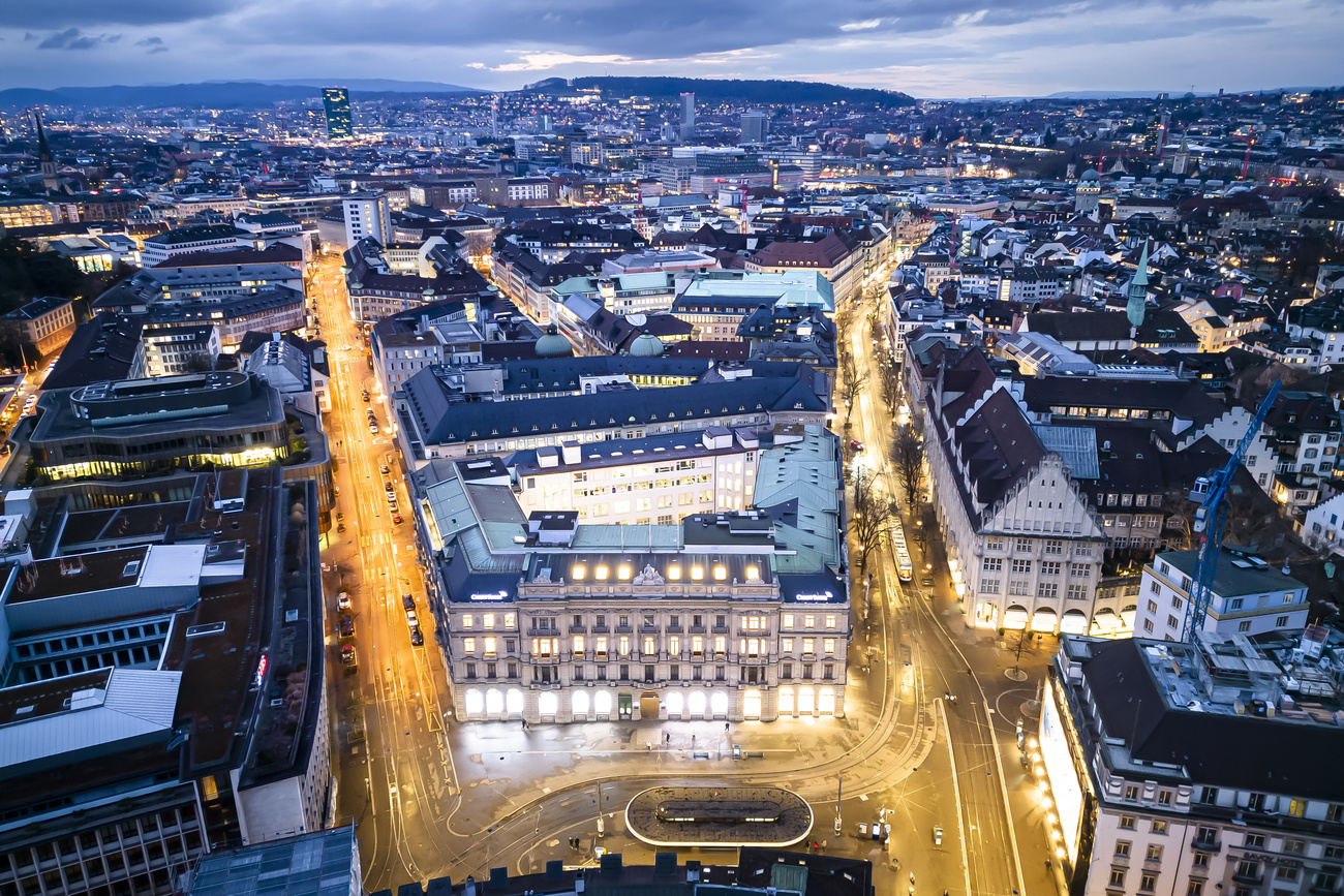 An aerial view shows Zurich’s Paradeplatz with the lights on and road lit up at dusk