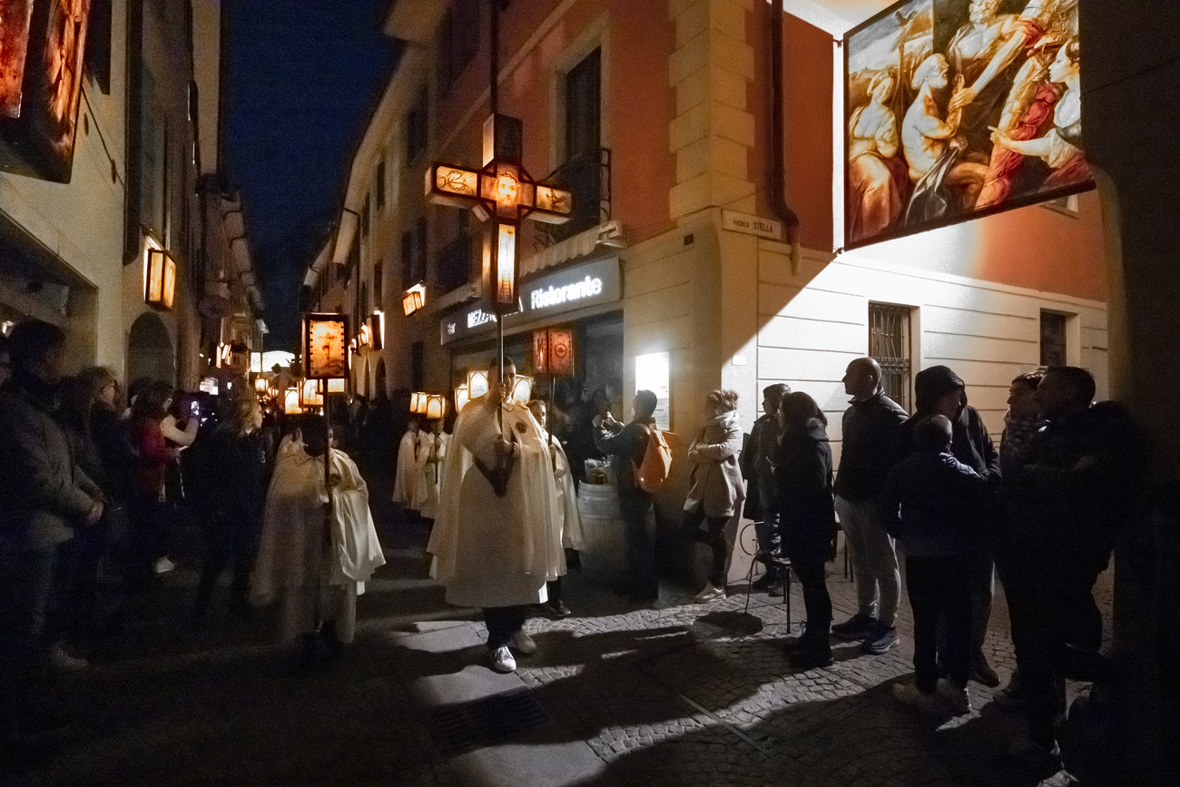 Bewohnerinnen und Bewohner aus der Region Mendrisio tragen beleuchtete Laternen mit der Geschichte des Leidenswegs von Christi durch die Altstadt von Mendrisio.