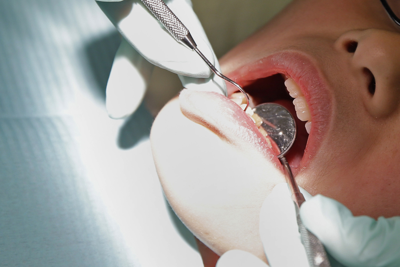 primo piano di una bocca che viene analizzata da un dentista