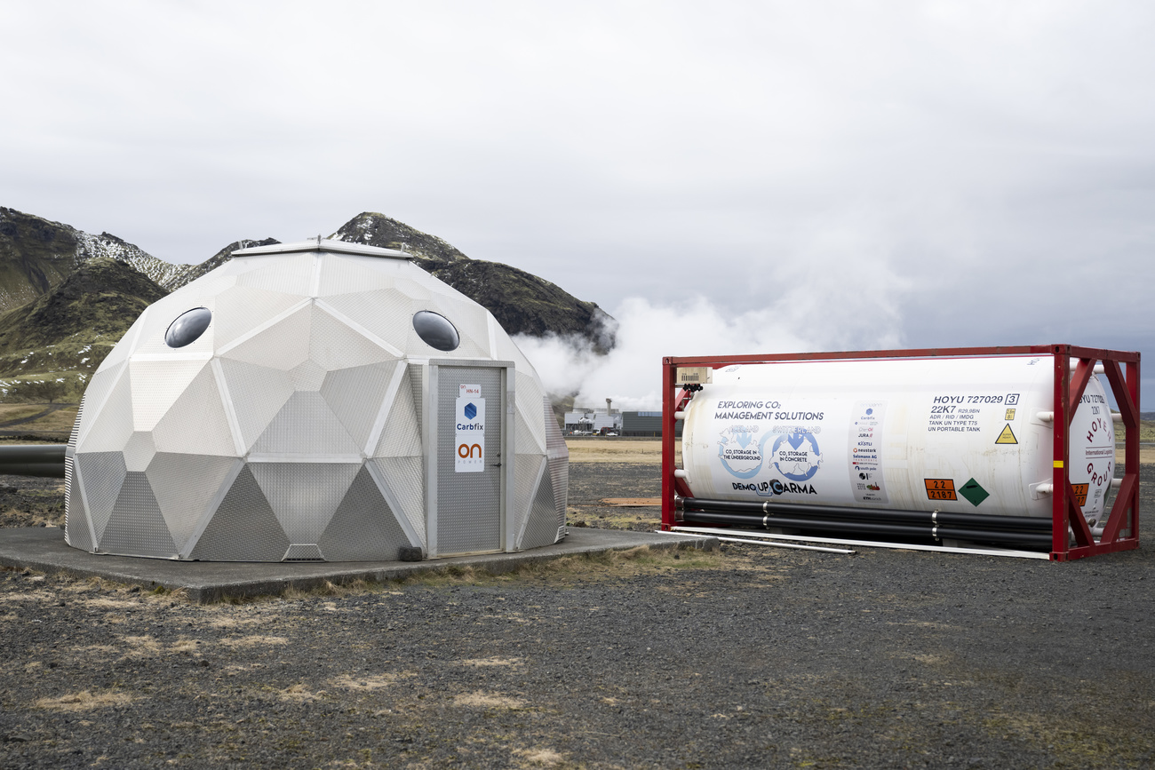 una struttura a forma di igloo e un grosso contenitore cilindrico in un paesaggio brullo