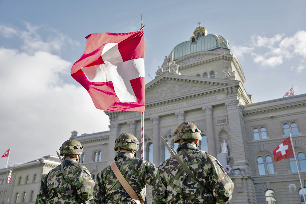 Der Fahnentraeger haelt die Schweizer Fahne der Ehrengarde der Schweizer Armee kurz vor dem Staatsbesuch des franzoesischen Praesidenten Emmanuel Macron und seiner Frau Brigitte Macron, auf dem Bundesplatz vor dem Bundeshaus, in Bern, am Mittwoch, 15. November 2023. (KEYSTONE/Anthony Anex)