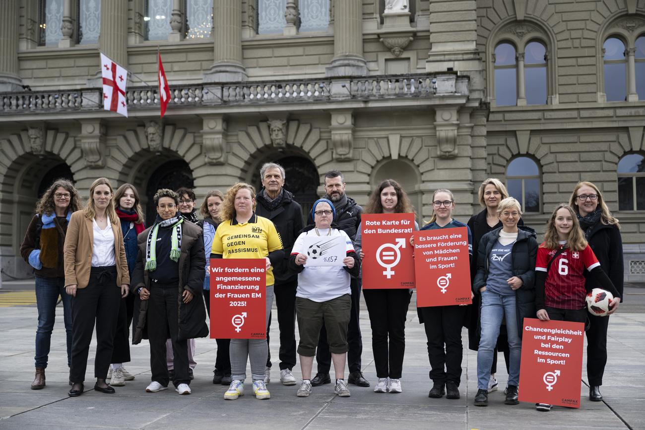 Picture of a group of people with signs in front of the Swiss Parliament