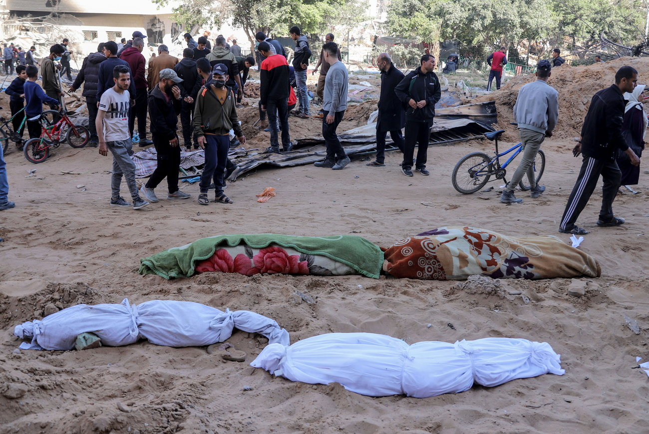 Des corps sont recouverts dans des linceuls à proximité des décombres de l'hôpital d'Al-Shifa, détruit par des frappes israéliennes à Gaza.