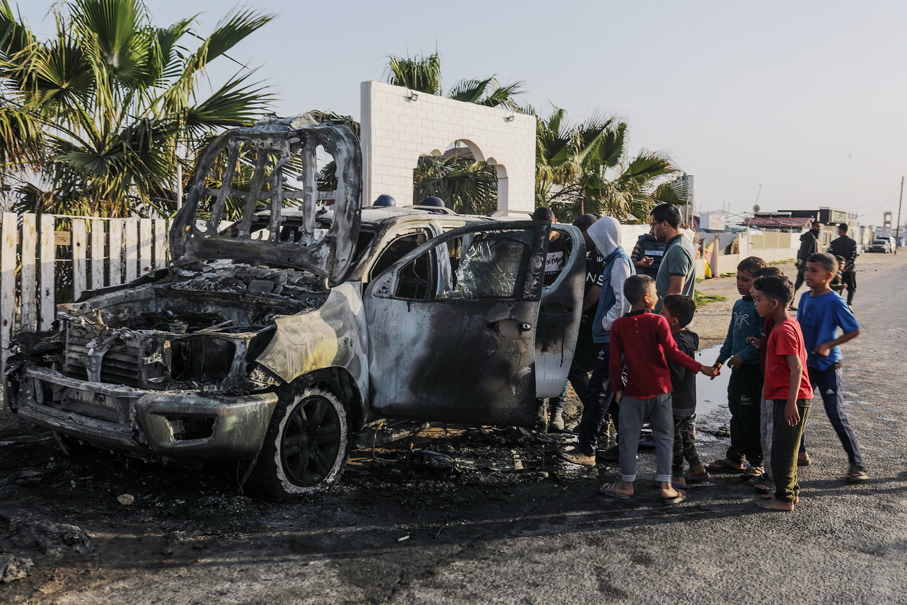 Alcune persone attorno all'auto dell'ong statunitense raggiunta dal missile israeliano.