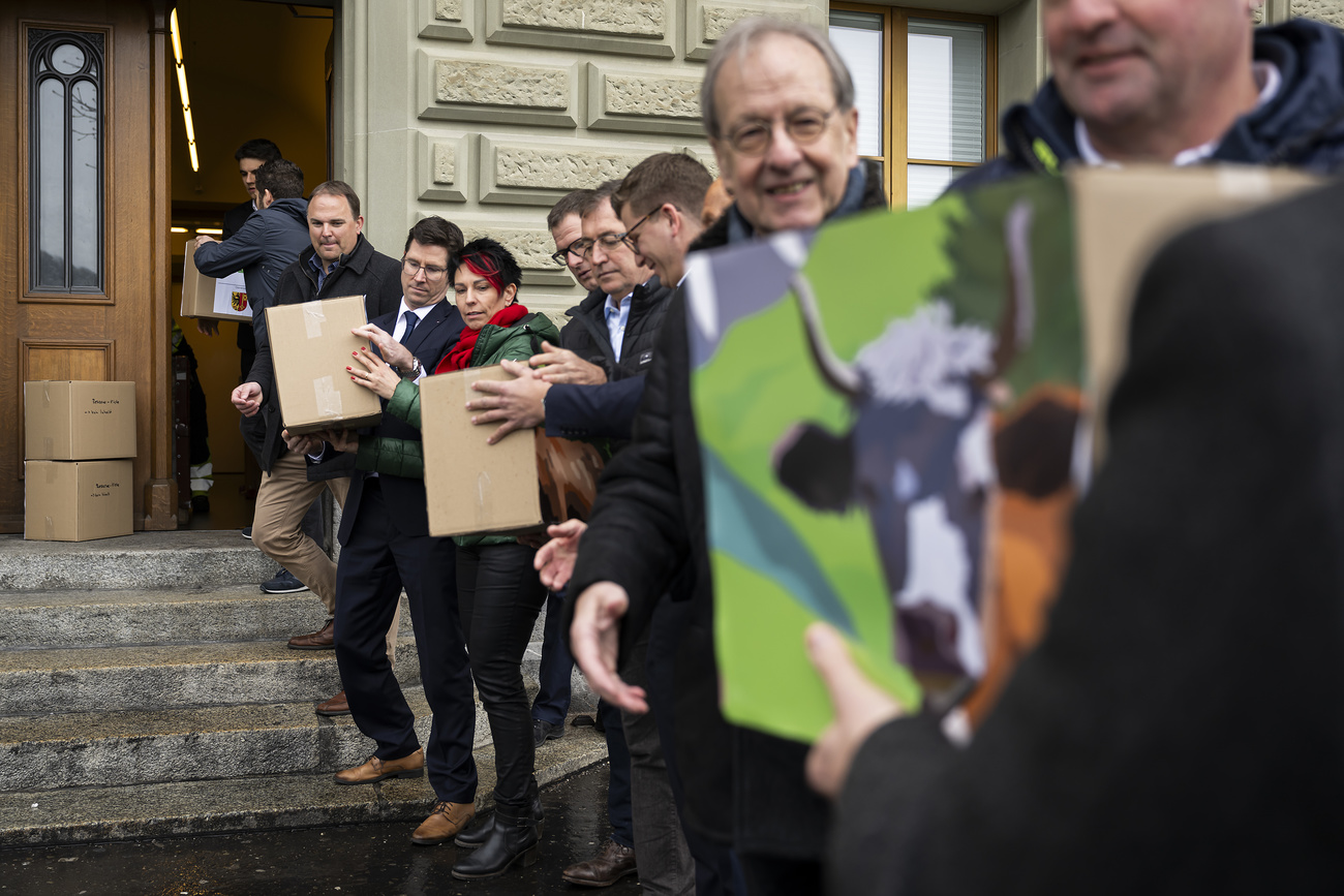 SVP-Mitglieder reichen einander Boxen mit Unterschriften