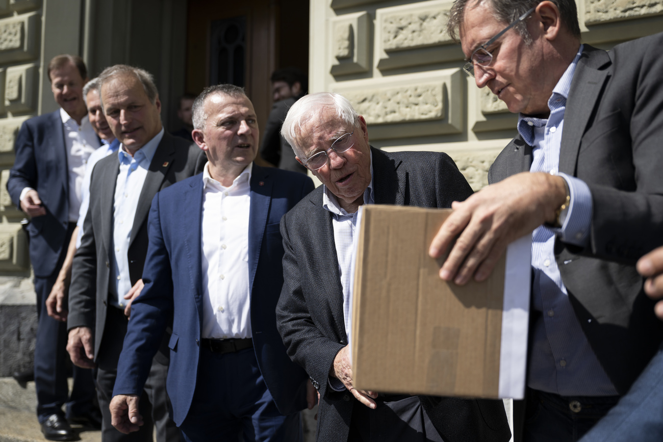 Christoph Blocher, with Roland Rino Buechel, Walter Wobmann, Pierre-Andre Page, Adrian Amstutz, and Stephan Rietiker hand over a box containing the signatures in front of the Federal Chancellery in Bern.