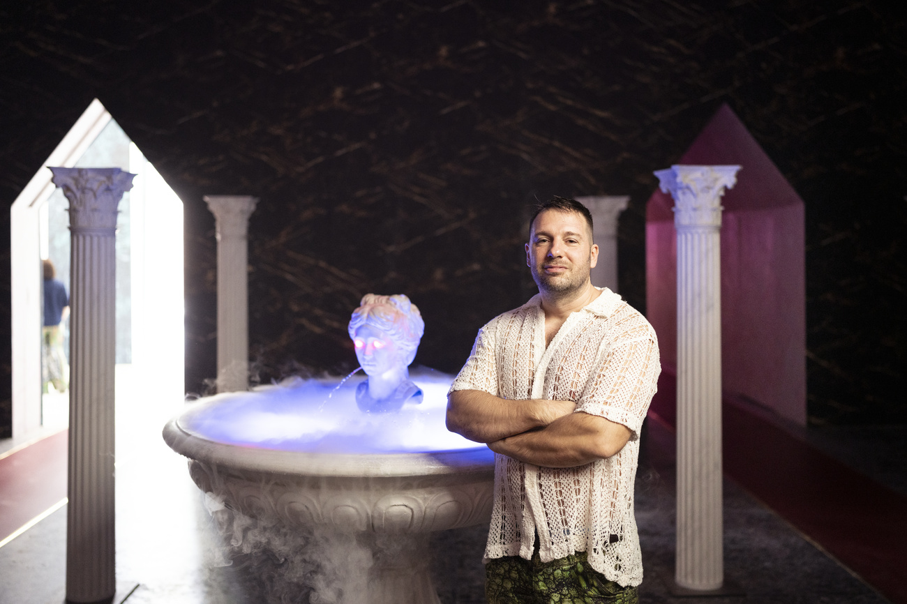 Guerreiro do Divino Amor在“赫尔维蒂喷泉”(Fountain of Helvetia)前留影,这是威尼斯瑞士展厅内装置作品的一部分。