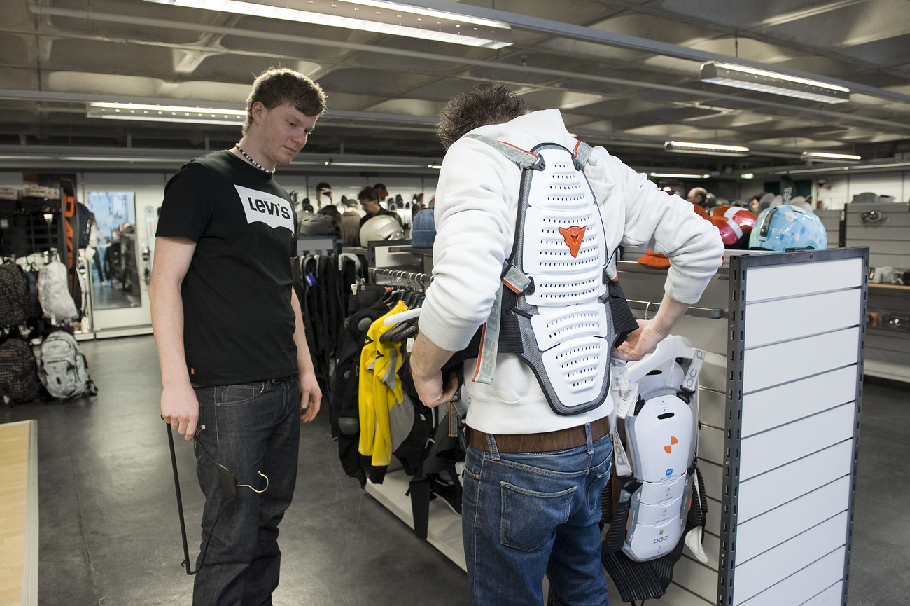 A shop assistant provides a customer with advice on back protectors at the Vaucher sports shop in Niederwangen in canton Bern.
