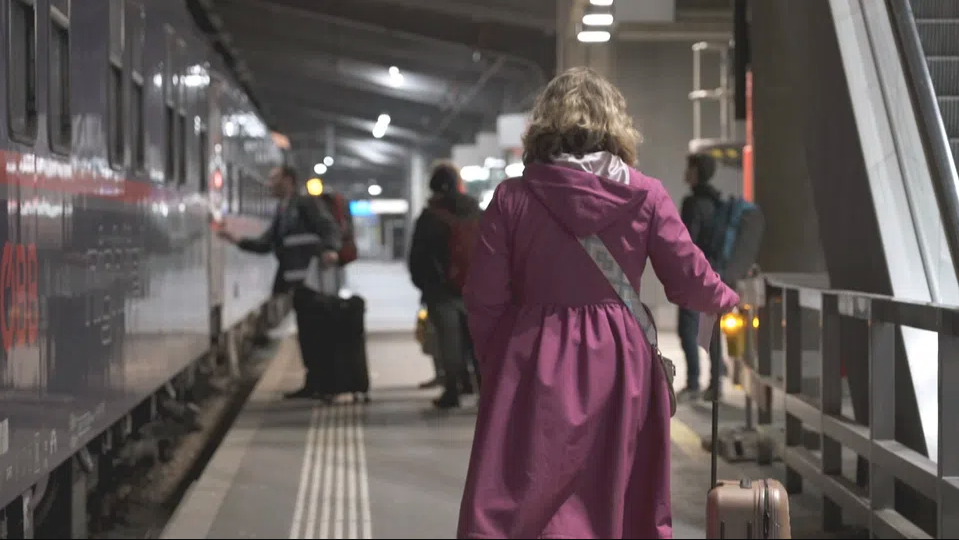 Femme avec une valise dans une gare.