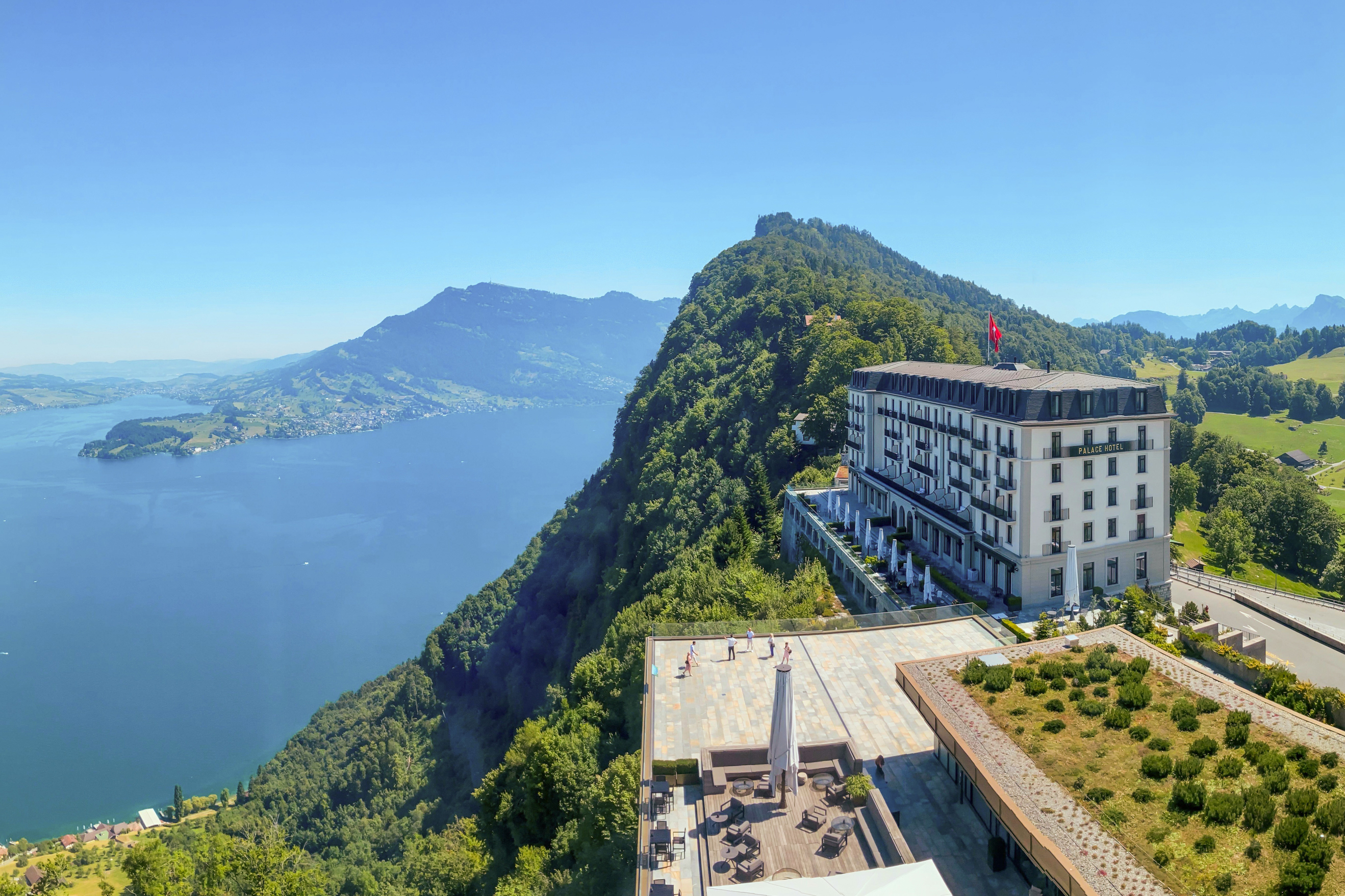 Panoramablick über das Hotel Palace und den Vierwaldstättersee und die Berge an einem sonnigen Sommertag in Burgenstock, Nidwalden, Schweiz.