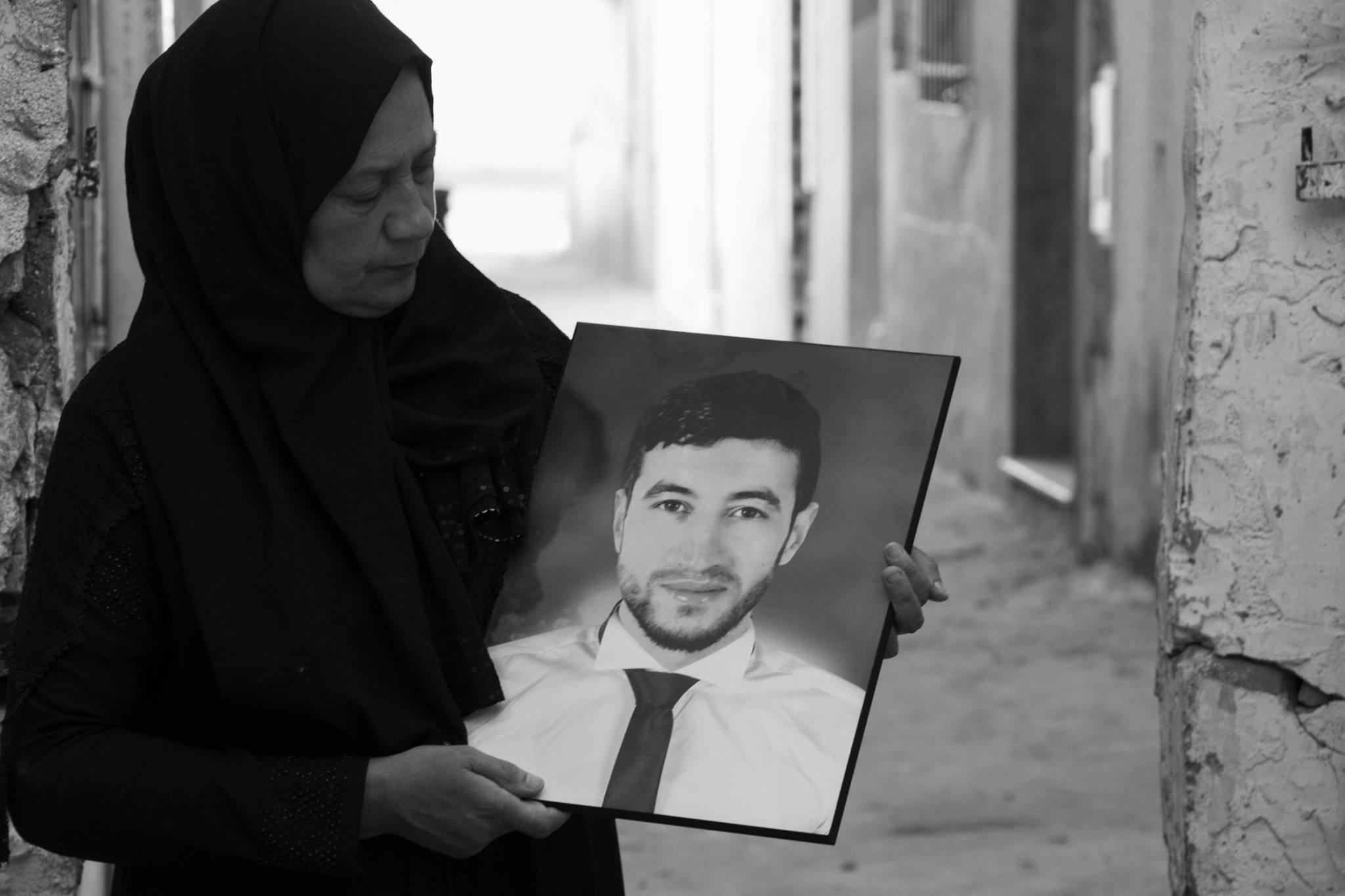 Madre tunisina in lutto tiene in mano la foto del figlio Mohammed Dia Arab, vittima della misura di controllo delle frontiere "S17".