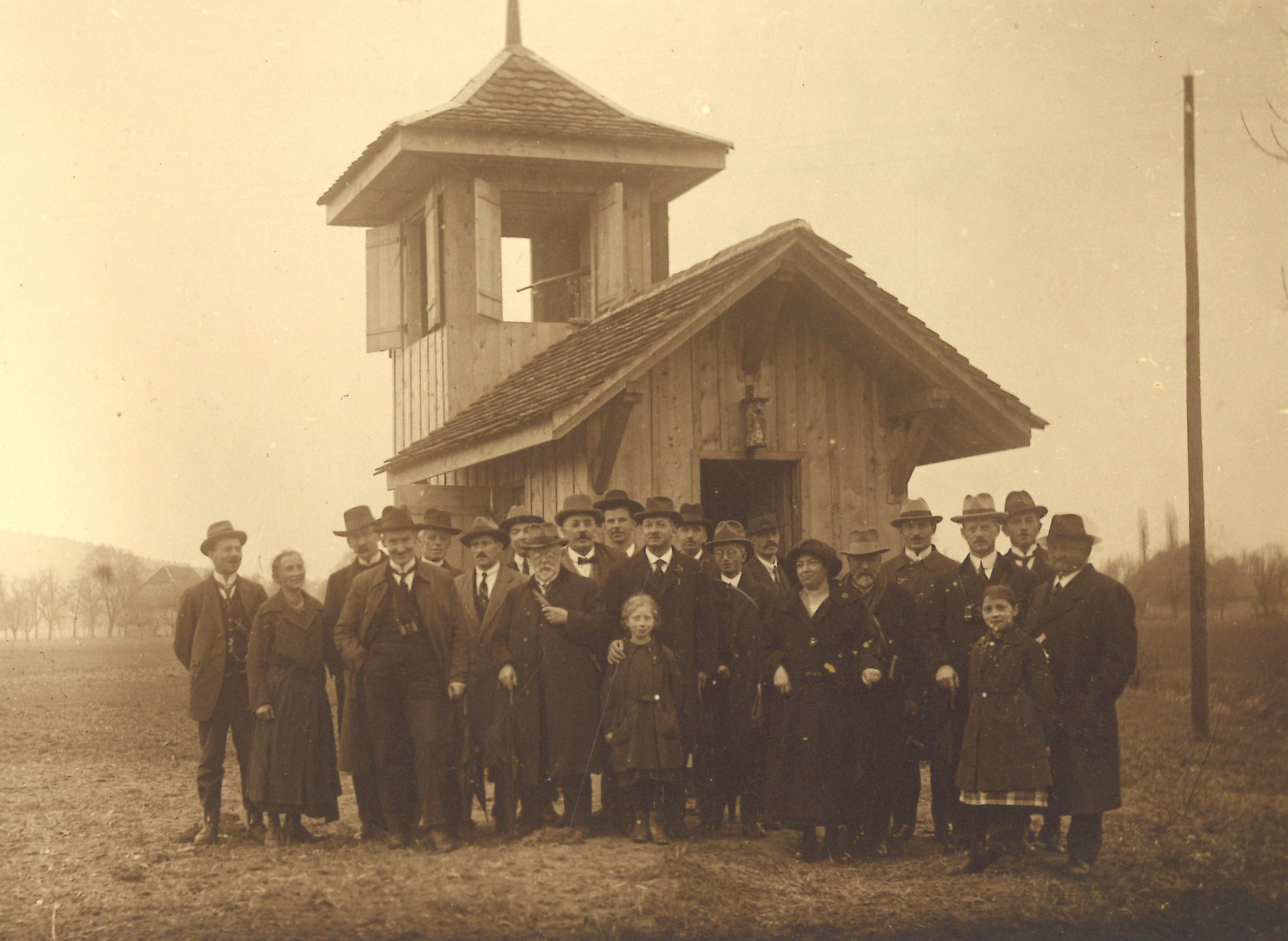 Altes Foto in Sepia: Gruppe von Menschen an der Eröffnungsfeier der Schweizerischen Vogelwarte.
