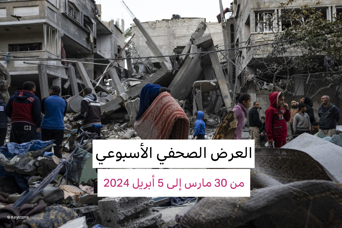 فلسطينيات وفلسطينيون يعاين.ون الدمار الذي لحق بمبانٍ سكنية بعد غارة جوية إسرائيلية في رفح، جنوب قطاع غزة، يوم الأحد، 24 مارس 2024.