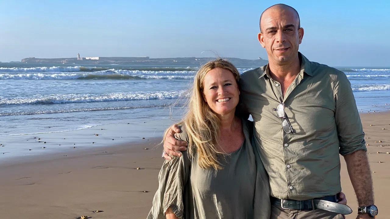 Nicole Pavlin und ihr Mann stehen Arm in Arm am Strand.